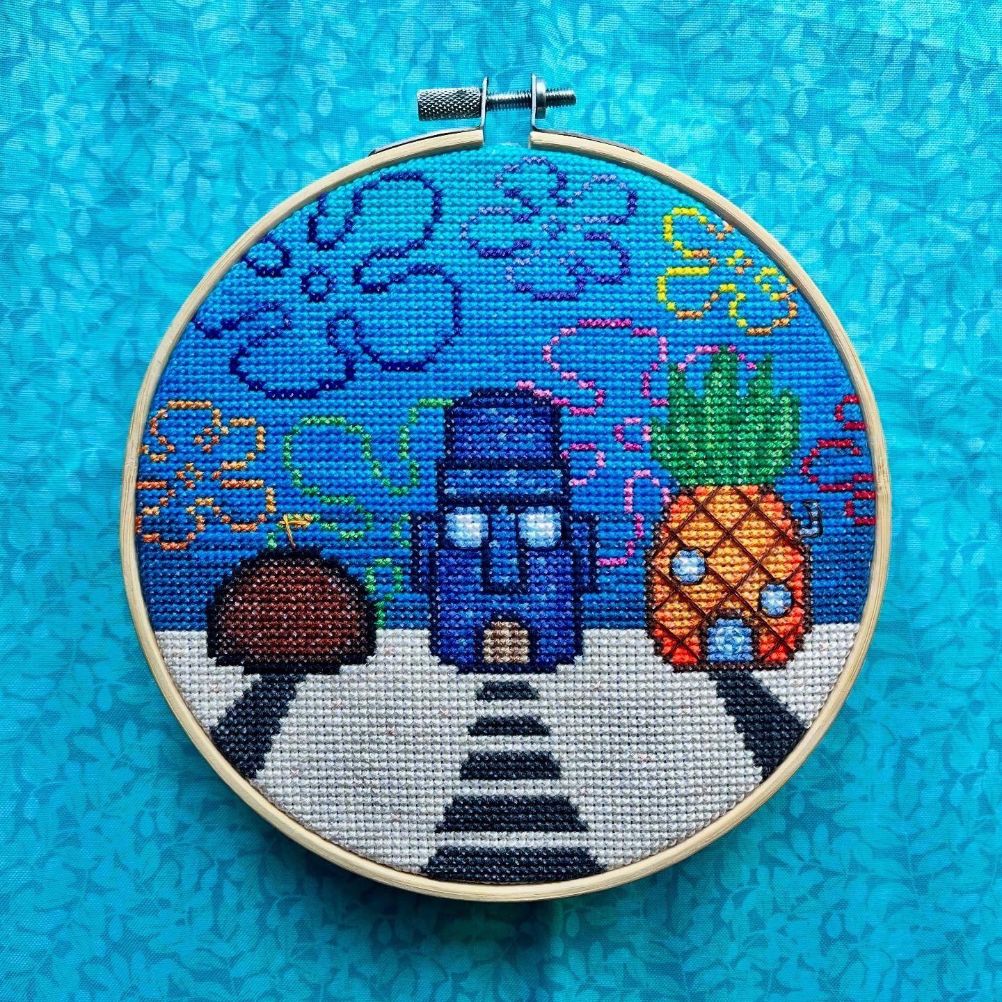 A cross stitched depiction of an underwater neighborhood